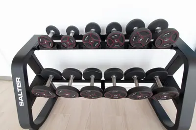 a black rack filled with dumbbells on a floor at Global Vacacional, Apartamento con terraza y vistas a la piscina en Gran Canet in Canet de Berenguer