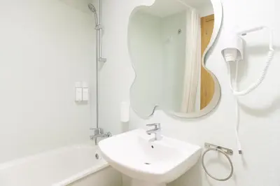 a white bathroom with a sink and a mirror at Tu refugio en Canet, piscina, parking y playa in Canet de Berenguer
