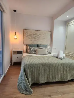 a bedroom with a large bed with a green blanket at FLORIT FLATS - The Apolo Apartment in Valencia