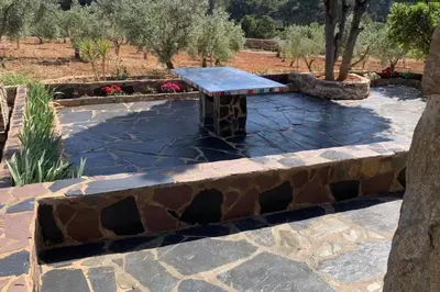 a stone bench sitting on a stone patio at El-cortijo in Siete Aguas