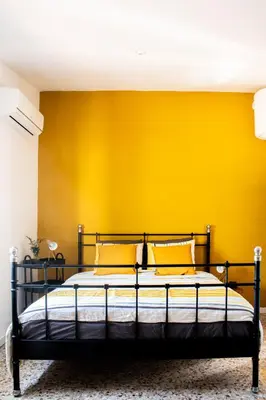 a bed in a room with a yellow wall at Casa Mas Montañas in Godelleta
