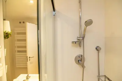 a bathroom with a shower with a sink and a mirror at Cullera Beach Apartment Cap Blanc in Cullera