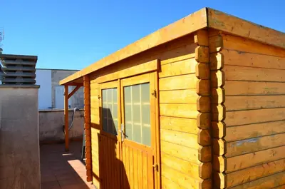 a wooden cabin with a door on a roof at FeWo - Moncofa Apartment in Moncófar