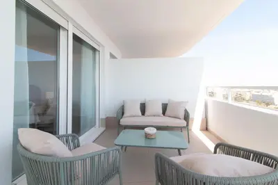 a balcony with chairs and a table and a couch at Moderno apartamento con vistas a la costa mediterranea en Gran Canet in Canet de Berenguer