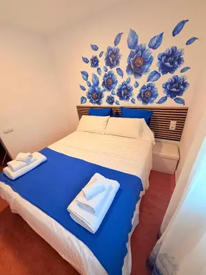 a bedroom with a bed with blue flowers on the wall at Habitaciones con cocina y baño privado de temporada Vacaciones largas Long Stay desde 11 noches in Valencia