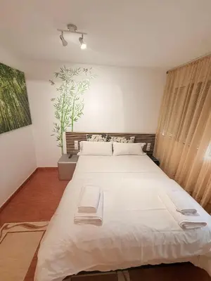a bedroom with a large bed with white sheets at Habitaciones con cocina y baño privado de temporada Vacaciones largas Long Stay desde 11 noches in Valencia