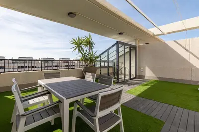 a patio with a table and chairs on a balcony at ApartUP Patacona Sunrise Duplex I in Valencia