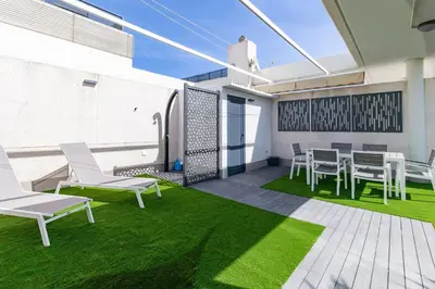 a patio with chairs and a table and grass at ApartUP Patacona Sunrise Duplex I in Valencia