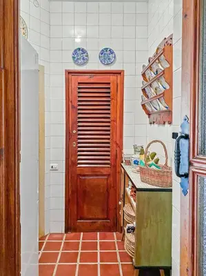 a kitchen with a wooden door and a tile floor at Huerto Valenciano - Sol y Tranquilidad - Piscina in Valencia