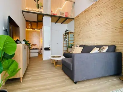 a living room with a couch and a brick wall at B3 Verdeguer - Cozy Loft Close to the Beach in Valencia
