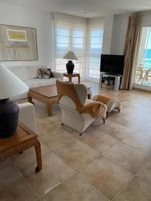 a living room with a couch and chairs and a television at FRENTE AL MAR in Burriana