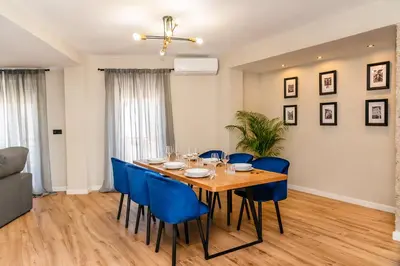 a dining room with a wooden table and blue chairs at El Labrador in Anna