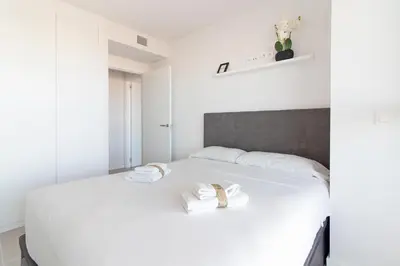 a bedroom with a white bed with towels on it at Global Vacacional, Apartamento para 5 personas con terraza in Canet de Berenguer