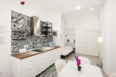 a kitchen with white cabinets and a table and chairs at El Mosaico Apartment in Valencia