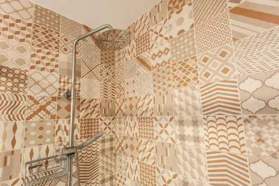 a bathroom with a shower with a tiled wall at El Mosaico Apartment in Valencia