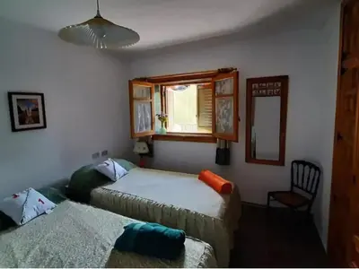 a bedroom with two beds and a window and a chair at Villa near Valencia with Private Pool in Valencia