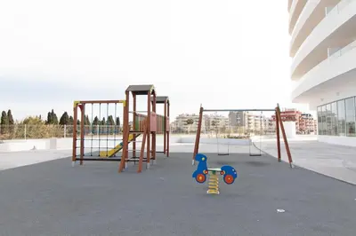 a playground in a building with a swing set at Global Vacacional, Apartamento con amplia terraza con vistas al mar in Canet de Berenguer