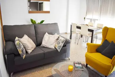 a living room with a gray couch and a table at Departamento céntrico para disfrutar en familia in Sagunto