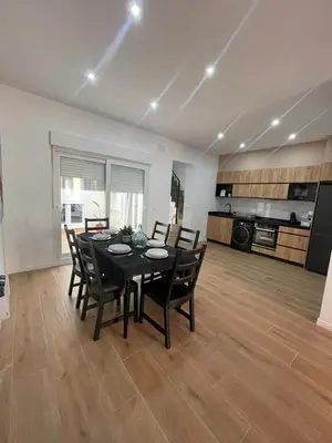 a dining room with a table and chairs and a kitchen at UIM Mediterraneo CASA Sepulveda Wifi in Puerto de Sagunto