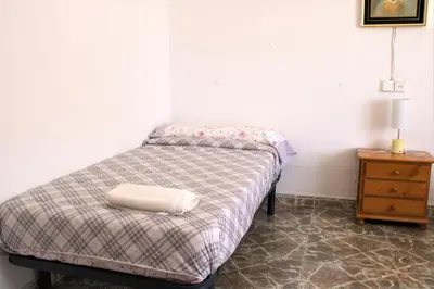a small bedroom with a bed and a night stand at Vacansis Habitaciones Privada en una Villa a un paso del Mar en Cullera in Cullera