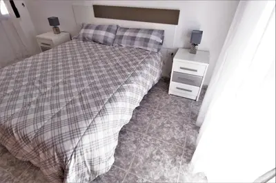 a bedroom with a bed and two night stands at Vacansis Habitaciones Privada en una Villa a un paso del Mar en Cullera in Cullera