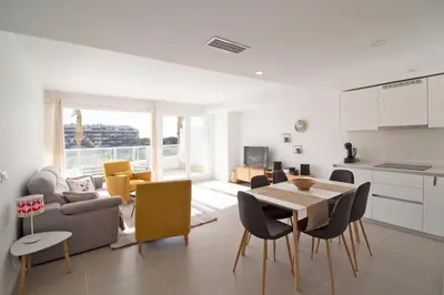 a kitchen and living room with a table and chairs at Global Vacacional, Apartamento para 5 personas con terraza y vistas a la piscina in Canet de Berenguer