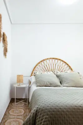 a bedroom with a large bed with a wooden headboard at Almar Collection Cullera AT in Cullera