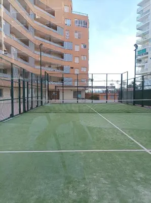 a tennis court in front of a building at Almar Collection Cullera AT in Cullera