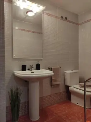 a bathroom with a sink and a toilet and a mirror at Precioso apartamento en Puerto de Sagunto Valencia in Puerto de Sagunto