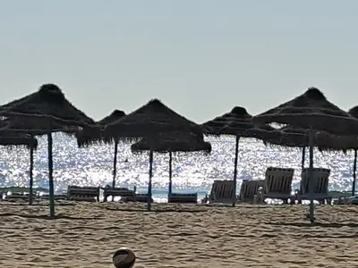 a group of chairs and umbrellas on a beach at 3 bedroom Flat with WiFi in Valencia