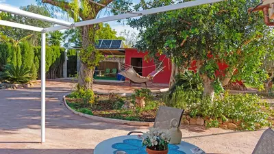 a patio with a hammock in front of a house at Orange Blossom Finca Unique in Valencia