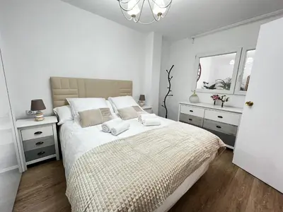 a white bedroom with a large bed and a window at Casa Isabel aeropuerto feria Valencia in Partida de La Cañada