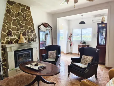 a living room with a table and a fireplace at Buenas vistas y privacidad, tranquila y fresca villa en el bosque de Valencia con una magnífica piscina de 80m2 in Lliria