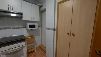 a small kitchen with white cabinets and a microwave at Valencia Centro andando y Playa malvarrosa tranvía in Valencia