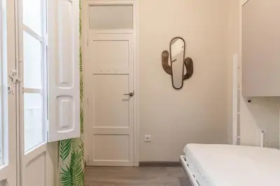 a bedroom with a bed and a mirror on the wall at Gran Vía by District Key in Valencia