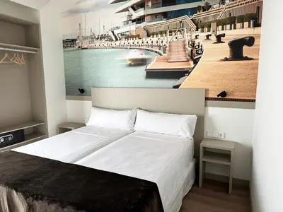 a bedroom with a large bed with a painting of a harbor at Hotel BESTPRICE Valencia in Valencia