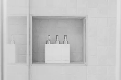a shelf with three bottles on it in a bathroom at Espectacular piso reformado al lado del rio Turia in Valencia