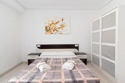 a bedroom with a bed with two towels on it at Global Vacacional, Apartamento de 4 habitaciones a 100 m de la playa in Puerto de Sagunto