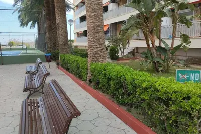 two benches sitting on a sidewalk in front of a building at Playa Puebla de Farnals Valencia in Masalfasar