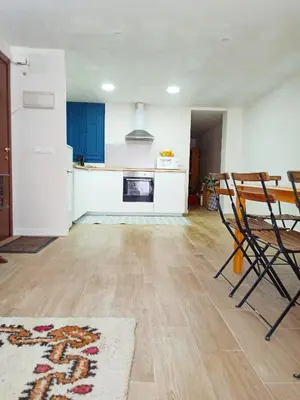 a kitchen with blue cabinets and a table and chairs at Vistas a las palmeras in Burjasot